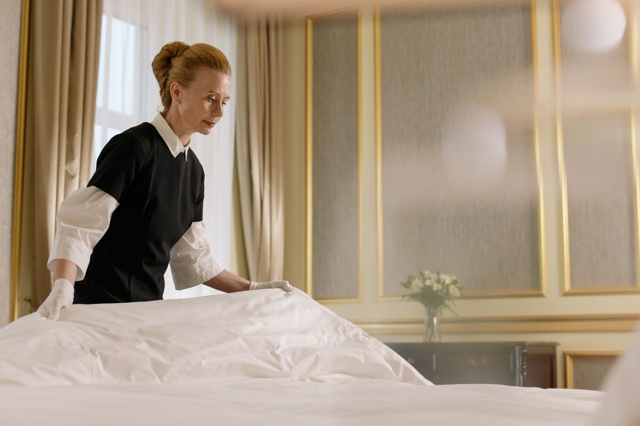gallery-05 A professional housekeeper fixes a bed in a luxurious hotel room.